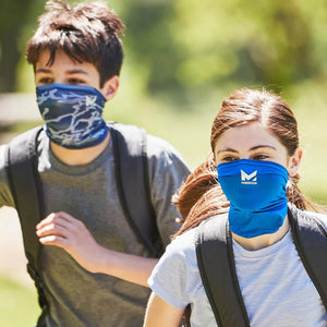 Two people wearing Mission brand blue neck gaiters while walking outdoors