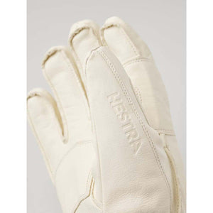 Close up of off white Hestra leather glove with embossed logo
