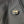 Close up of a black and orange heated jacket power button with a logo