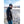 Man wearing a Mobile Warming charcoal grey hoodie and beanie standing by a rocky riverbank