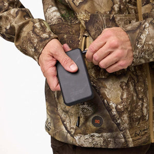 Person connecting a Mobile Warming battery pack to a heated camouflage jacket