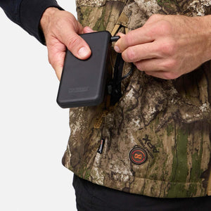 Person connecting a Mobile Warming power bank to a camouflage heated vest