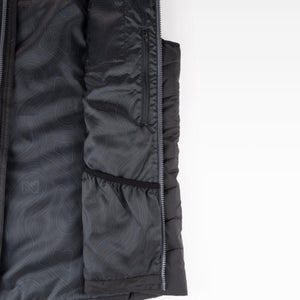 Interior view of a black Mobile Warming vest showing the lining with a topographic pattern and a zippered pocket