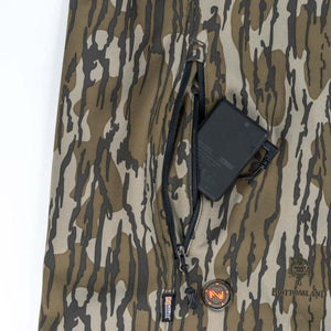 Mobile Warming battery pack inside zippered pocket of Mossy Oak Bottomland camouflage fabric