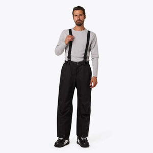 Man wearing Mobile Warming black snow pants with suspenders and a grey long sleeve shirt