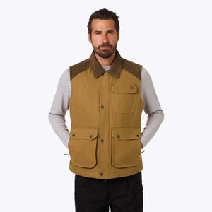 Man wearing a tan Mobile Warming canvas vest with brown collar and multiple pockets