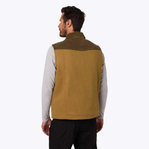 Back view of a man wearing a tan and olive Mobile Warming vest over a grey long sleeve shirt