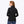 Back view of a woman wearing a black Mobile Warming long sleeve zip up jacket with blue jeans