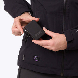 Hands placing a Mobile Warming battery pack into a jacket pocket