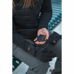 Person holding a Mobile Warming battery pack connected to a heated glove