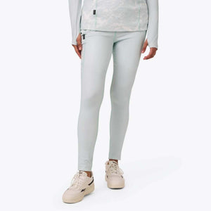 Mobile Warming light blue leggings worn with a matching long sleeve top and beige sneakers