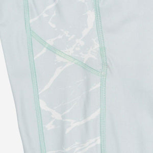 Mobile Warming leggings featuring light blue fabric with white marble pattern side panels and stitched seams