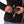 Hands connecting a battery pack into the pocket of a black Mobile Warming fleece jacket