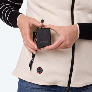 Person holding a Mobile Warming battery pack connected to a heated vest