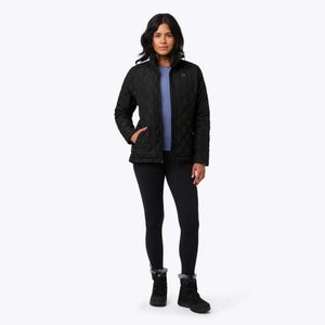 Woman wearing a black quilted Mobile Warming jacket over a blue shirt and black leggings