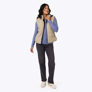 Model wearing a beige Mobile Warming sherpa vest over a blue long sleeve shirt and black jeans