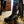 Muck brown rubber chore boot worn in a stable with horse legs visible in background