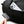 Bellroy black duffel bag with a white phone in the pocket and a hand holding a black leather key cover