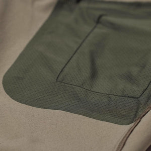 Close up of FjallRaven garment showing textured olive green pocket overlay on tan fabric