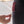 Hand pulling the pin on a red Nathan personal safety alarm clipped to black leggings