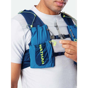 Person wearing a blue Nathan hydration vest with a straw