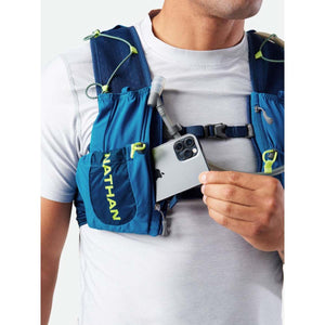 Person wearing a blue Nathan hydration vest with a smartphone in the front pocket