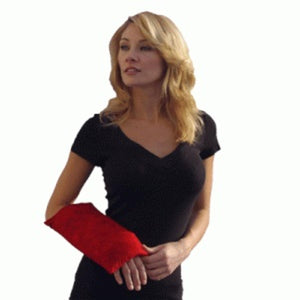 Woman wearing a red Nature Creation heating pad on her forearm