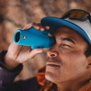 Person using a blue NOCS Provisions monocular