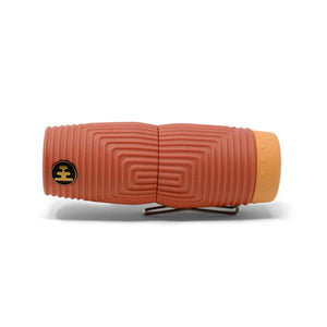 Terracotta colored textured cylindrical handheld device with a metal clip and yellow end cap