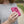 Person holding a pink O2 Cool portable neck fan
