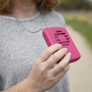 Person holding a pink O2 Cool portable neck fan