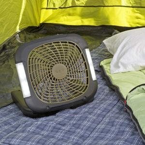 Portable camping fan with integrated LED lights sitting on a sleeping bag inside a tent