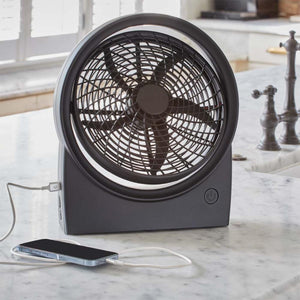 Treva portable desk fan charging a smartphone on a kitchen counter