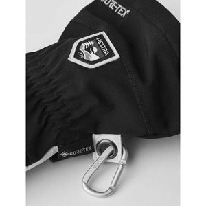 Black Hestra glove with Gore-Tex branding and attached metal carabiner