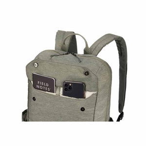 Thule backpack with front pocket containing a Field Notes notebook and a smartphone