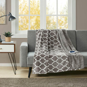 Grey and white patterned electric throw blanket draped over a grey sofa