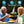 Man and woman wearing Ontel neck fans while sitting outdoors with drinks