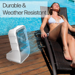 Ontel portable fan on a wooden pool deck next to a woman relaxing on a lounge chair