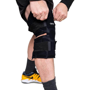Person adjusting a black Onyx Ortho knee brace on their leg