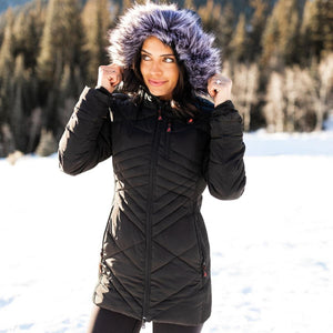 Woman wearing a black ActionHeat quilted parka with a faux fur hood in a snowy landscape
