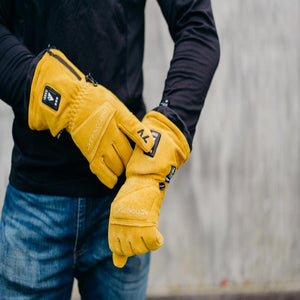 Person wearing yellow ActionHeat battery heated gloves with visible power buttons