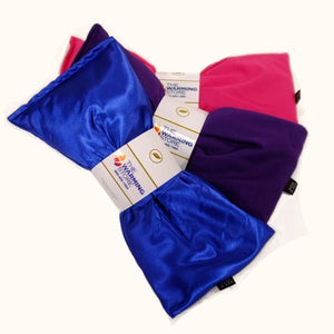 Three Herbal Packs heating pads in blue pink and purple fabric with The Warming Store branding