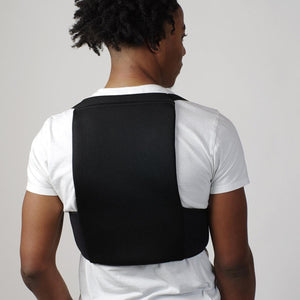 Person wearing Oro Sports black mesh back support brace over a white t-shirt