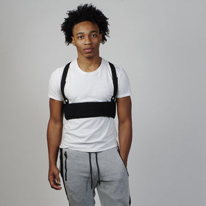 Person wearing an Oro Sports black chest support brace over a white t-shirt