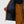 Interior view of an open brown ski jacket showing navy blue lining and mesh pockets over matching brown ski bibs
