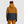 Back view of person wearing Outdoor Research two-tone mustard and navy hooded ski jacket with Smith beanie