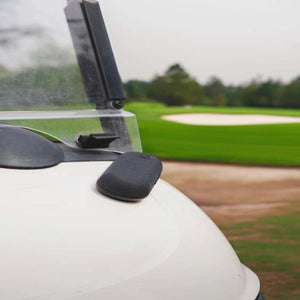 Outdoor Tech speaker mounted on a golf cart hood with a golf course in the background