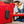 Outdoor Tech black portable speaker hanging from a red storage bin
