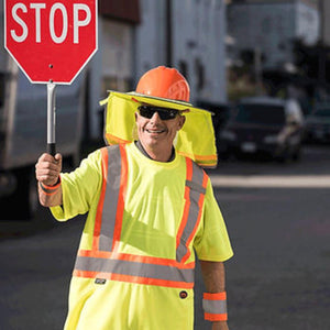 Pioneer traffic controller wearing high visibility shirt and hard hat with neck shade holding a stop sign