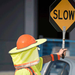 Pioneer hard hat sun shade with neck protector on a worker holding a slow sign